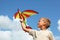 Boy plays kite against sky