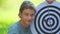 A boy plays an outdoor darts game.