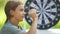 A boy plays an outdoor darts game.