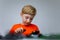 A boy plays with a plastic constructor, examines a model assembled from parts