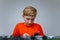 A boy plays with a plastic constructor, examines a model assembled from parts