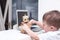 Boy plays with the robot on a white table at home