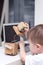 Boy plays with the robot on a white table home