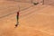 The boy plays tennis on the orange dirt court. Court hard