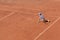 A boy plays tennis on an outdoor tennis court. The child is concentrated and focused on the game. match. Active sport