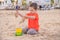 A boy plays a typewriter on the beach. Children`s games. Beach in the summer. Small child