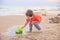 A boy plays a typewriter on the beach. Children`s games. Beach in the summer. Small child