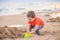 A boy plays a typewriter on the beach. Children`s games. Beach in the summer. Small child