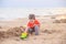 A boy plays a typewriter on the beach. Children`s games. Beach in the summer. Small child