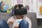Boy plays with virtual reality glasses, indoors. Digital virtual reality device