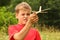 Boy plays with wooden airplane on nature