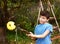 Boy pluck ripe apples from the tree with special device