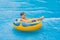 Boy on a pool float on artificial waves in a water park