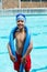 Boy with pool noodle smiling at camera