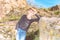 A boy poses for a photo shoot, leaning on a large rock on the rocks during a hike