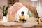 Boy with pots playing music in kids tent at home