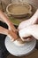 Boy on a pottery wheel with his hands pulls a mold in a pottery workshop, creative isolation. Family traditions