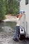 A boy pours water into a camper from a forest river from a five-liter bottle