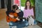 Boy practicing playing guitar, his sister sings