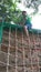 Boy practicing rope climbing in garden area