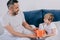 Boy presenting gift box for fathers day to smiling daddy