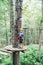 Boy in protective gear stands on a wooden platform in front of the agility bridge