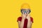 Boy in protective helmet and safety glasses on yellow background. Choice of future profession. Copy space