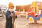 A boy in a protective mask plays in the playground and spills sand from his hands during the pandemic of coronavirus and Covid -