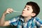 Boy pull chewing gum with his hand from moth