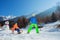 Boy pull uphill a little brother on wooden sledge at mountains