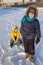 Boy pulling sled with his friend on snowy road