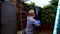 A boy punches a punching bag in blue gloves in the yard