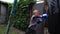 A boy punches a punching bag in blue gloves in the yard