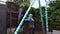 A boy punches a punching bag in blue gloves in the yard