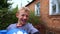 A boy punches a punching bag in blue gloves in the yard