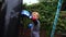 A boy punches a punching bag in blue gloves in the yard