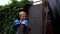 A boy punches a punching bag in blue gloves in the yard