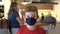 Boy puts on a protective mask at home looking at camera on First day School