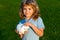 Boy putting money into a piggy bank. Portrait of a joyful cute little kid holding saving piggybank.