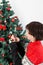Boy putting ornament on Christmas tree