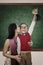 Boy raising trophy kiss by his mother in class