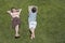 Boy Reading Besides Asleep Brother On Grass