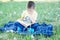 Boy reading book sitting in park outdoor among dandelion in park, smiling cute child, children education and development