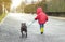 Boy in red coat and bulldog dog tied to his leash running in the rain. friendship Concept