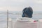 A boy in a red jacket and headphones looks at the sea waves in stormy weather