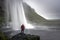 Boy with red jacket at seljalandsfoss