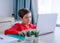 A boy in red shirt focusing on study in computer, homeschool concept.