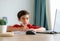 A boy in red shirt focusing on study writing on paper, homeschool concept.