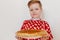 Boy in a red shirt holding a plate with pancakes