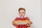 Boy in a red shirt holding a plate with pancakes. Pancakes in the foreground. The holiday of Maslenitsa